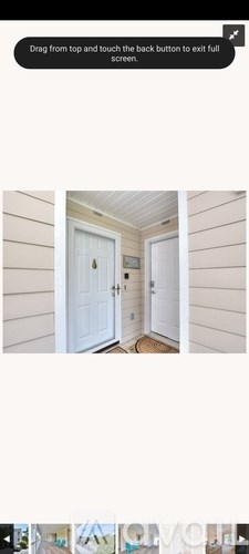A white door is in the center of a room with wooden walls.