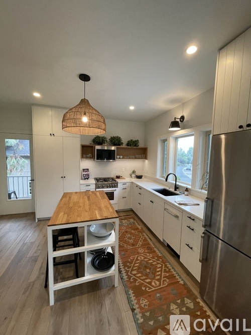 A kitchen with a wooden island and stainless steel appliances.