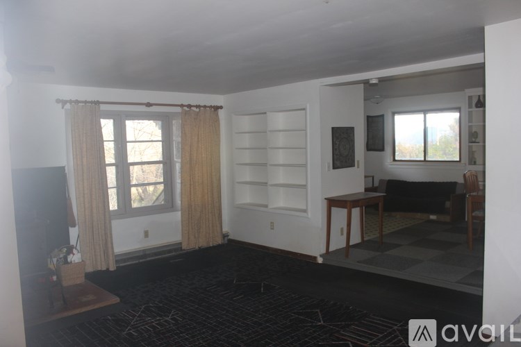 A living room with a black carpet and a checkered floor.