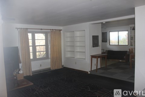 A living room with a black carpet and a checkered floor.