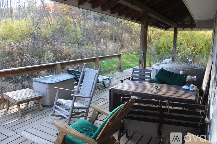 A wooden deck with chairs and a hot tub.