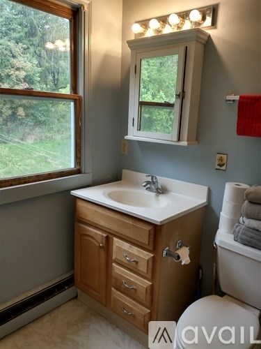A couch with pillows in front of a window.