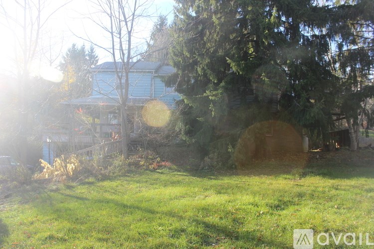 A house with a blue roof is surrounded by trees and grass.