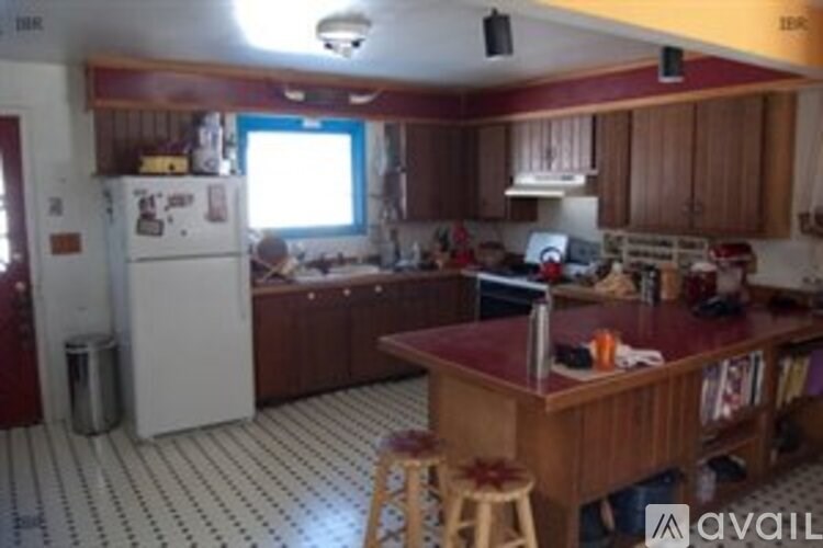 A kitchen with a white fridge and a black and white floor.