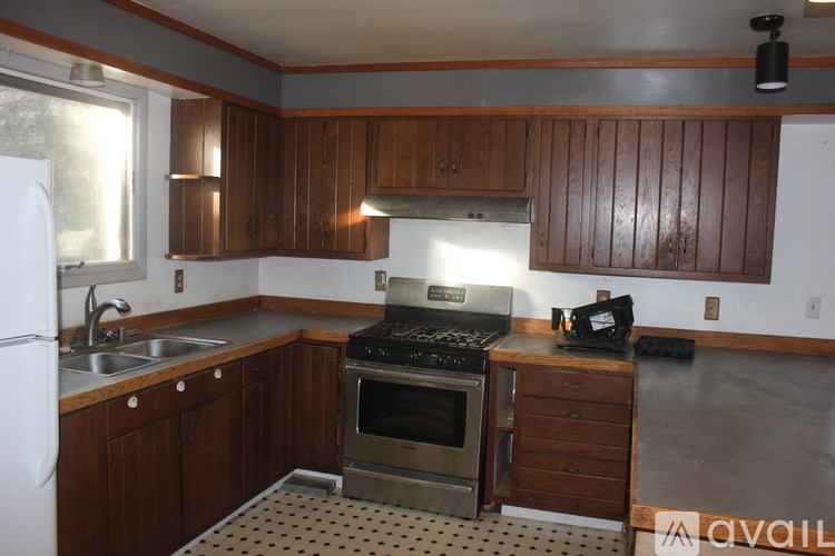 A kitchen with wooden cabinets and a stove top oven.