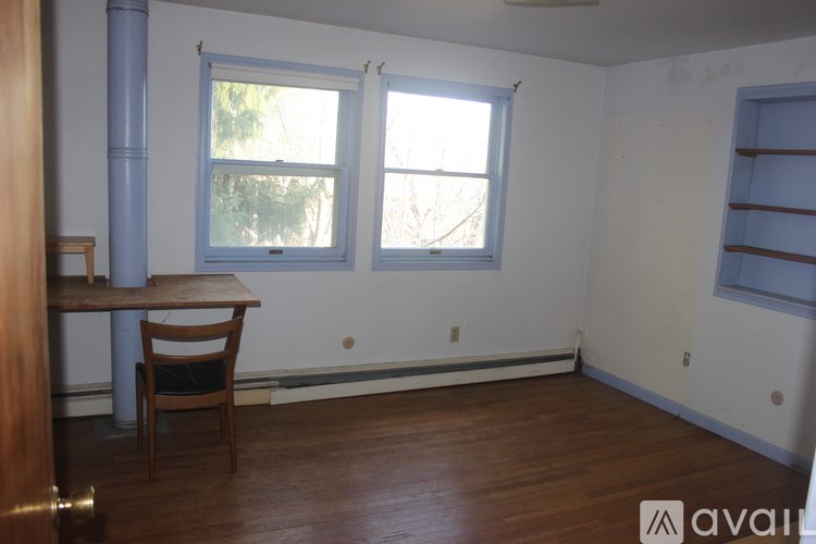 A bed with a blue blanket and a cartoon giraffe on it.