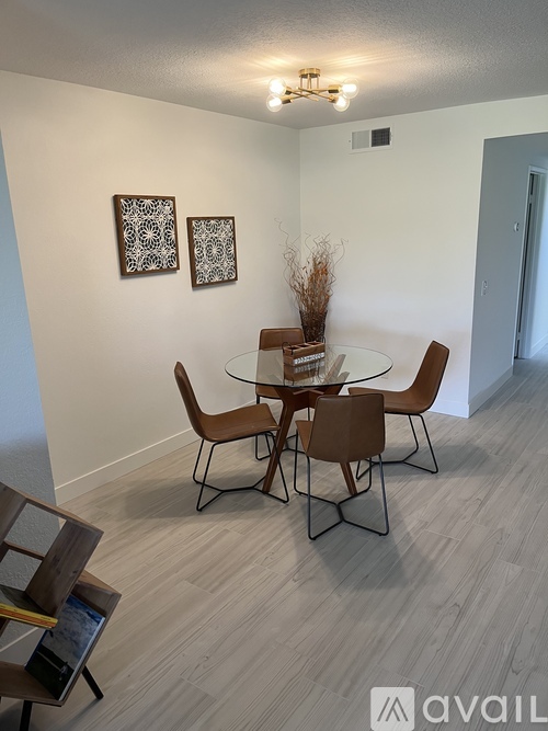 A dining room with a glass table and chairs.