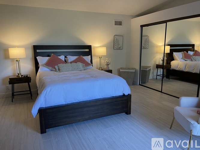 A bedroom with a large bed and a mirror on the wall.