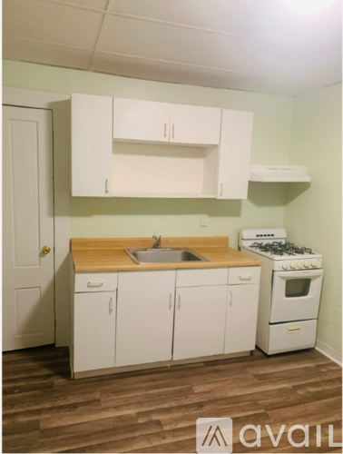 A white fridge in a room with a door and a carpet.