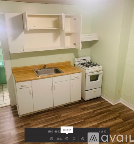 A small kitchen with a stove, sink, and a door.