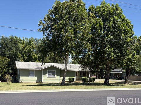A house with a white roof and a tree in front of it.