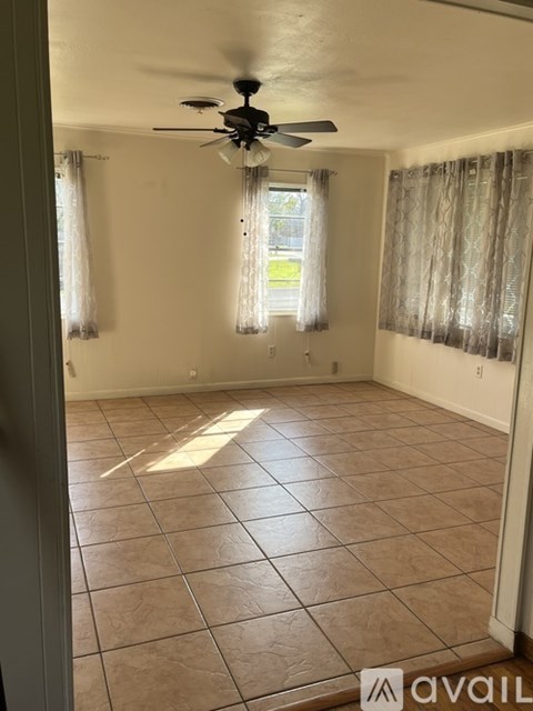 A room with a ceiling fan and tiled flooring.