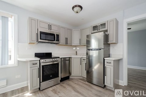 A kitchen with a stove top oven, microwave, and refrigerator.