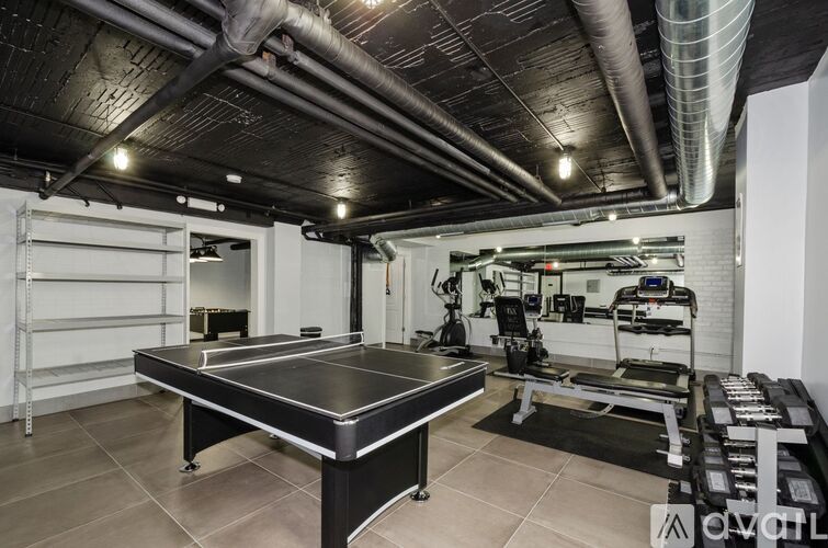 A gym with a black table in the center and a white wall on the right.