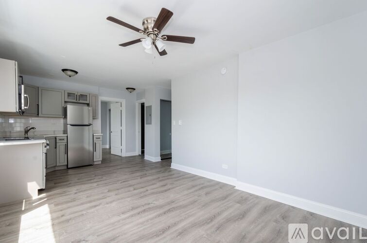 A spacious kitchen with a fan on the ceiling.