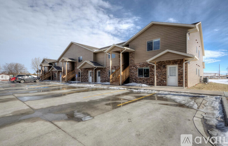 A large house with a parking lot in front.