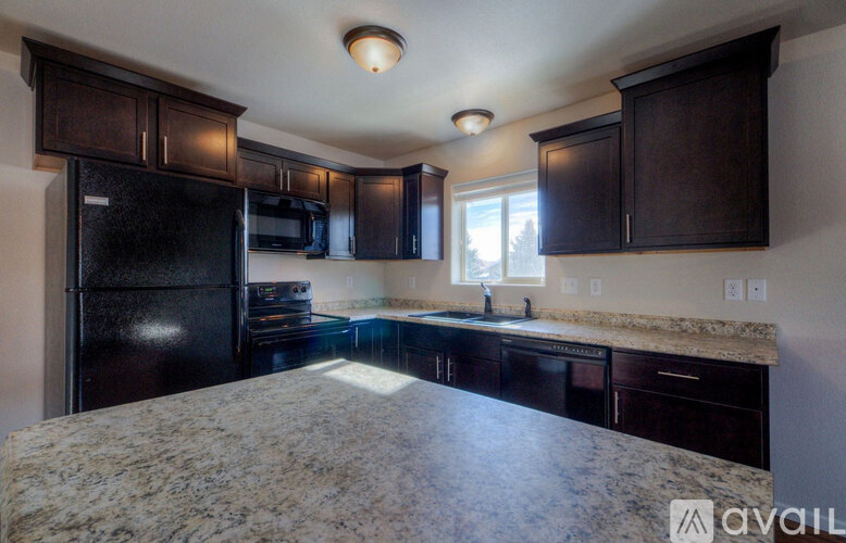 A kitchen with black cabinets and granite countertops.
