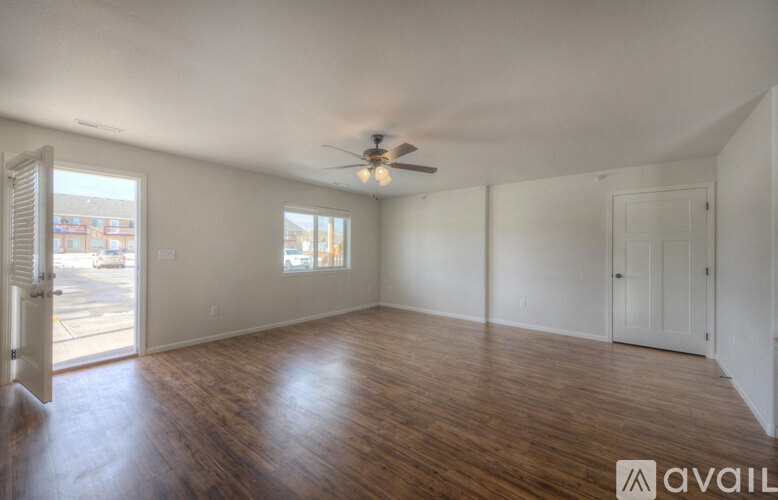 A room with wooden floors and a ceiling fan.