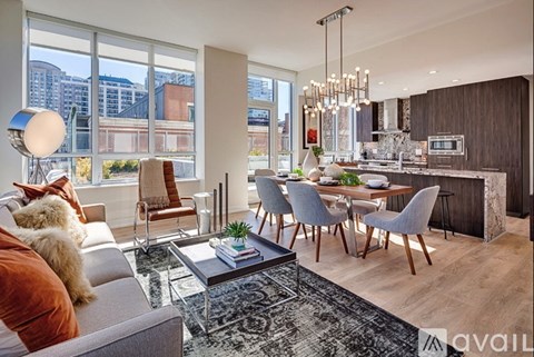 A modern living room with a grey sofa and a glass coffee table.