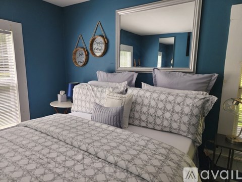 A bedroom with a large bed and a mirror on the wall.