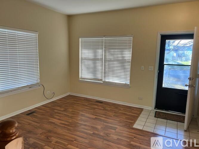 A room with wooden flooring and a door leading outside.