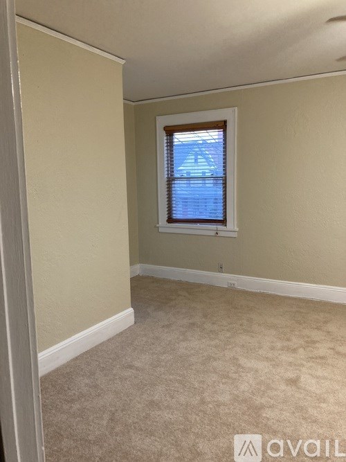 A room with a window and carpeted floor.