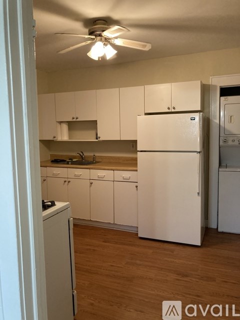A kitchen with white cabinets and a white refrigerator.