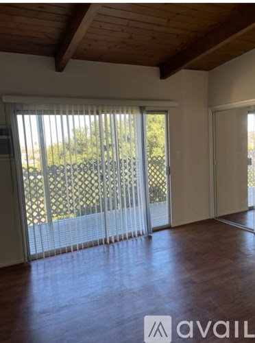 A room with wooden floors and a sliding glass door.