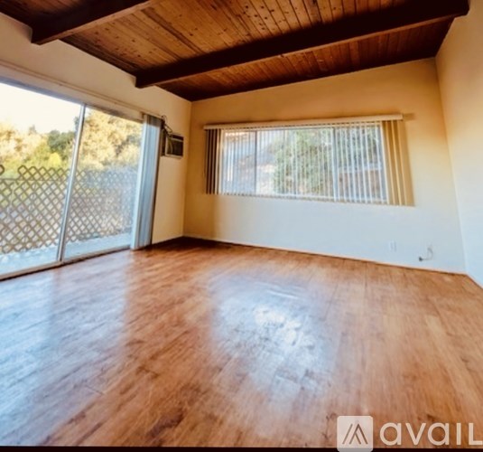 A wooden floor with a white staircase in the corner.