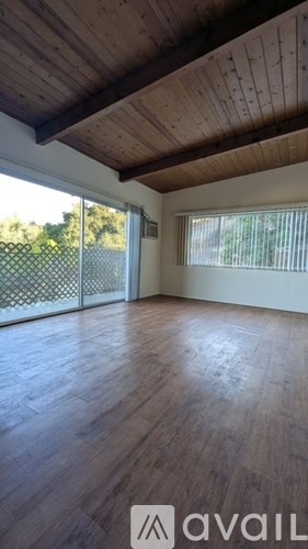 A room with wooden floors and a sliding glass door.