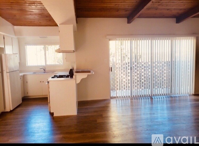 A kitchen with white cabinets and a black countertop.