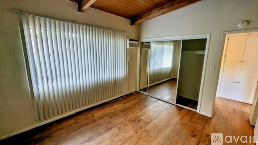 A sign for Mountain Shadow Apartments stands in front of a hedge.