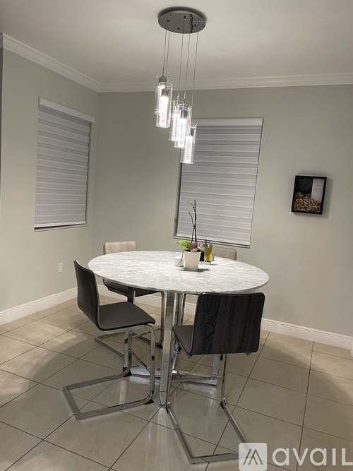 A dining room with a white table and chairs.