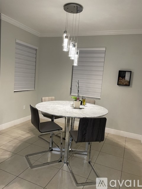 A dining room with a white table and chairs.
