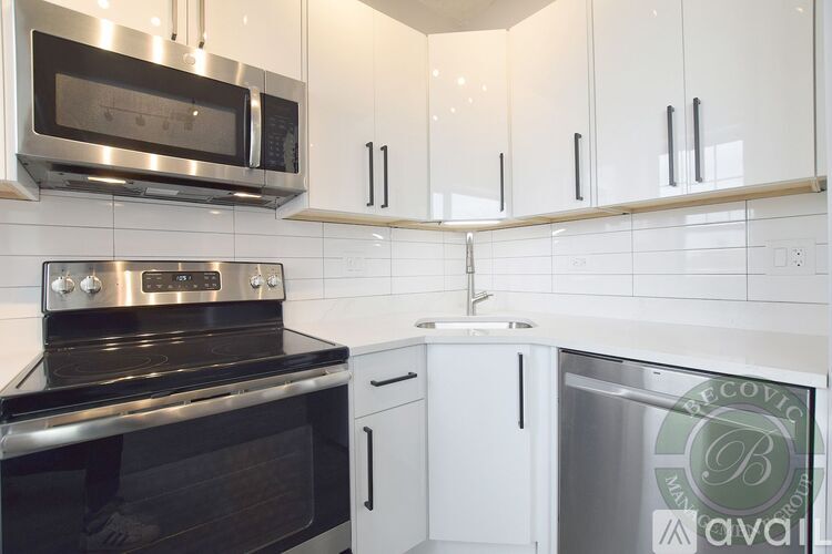 A kitchen with white cabinets and a stainless steel oven.