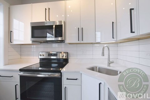 A kitchen with a stove, microwave, and cabinets.