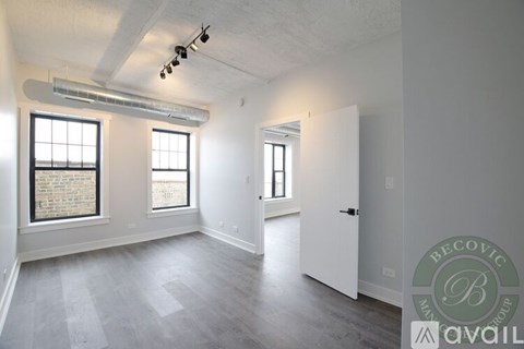 A spacious room with a window and a door.