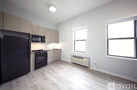 A kitchen with black appliances and a window.