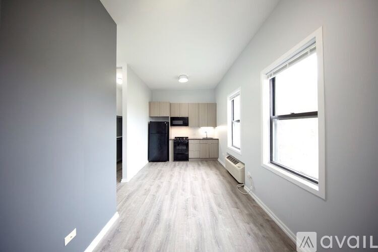 A spacious room with a kitchen area and a window.