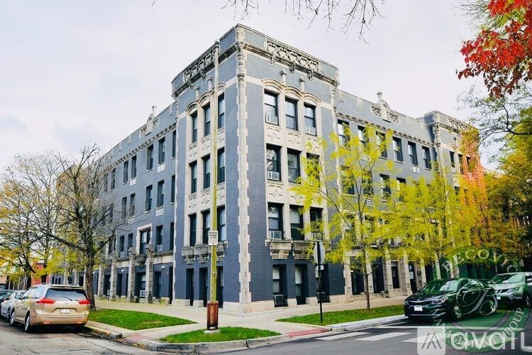 A grey building with a tree in front of it.