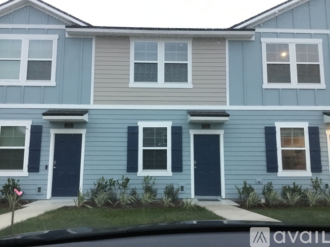 A blue house with a white window and a black door.