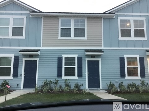 A blue house with a white window and a black door.
