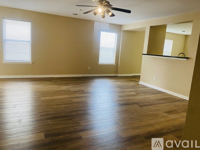 A room with wooden flooring and a ceiling fan.