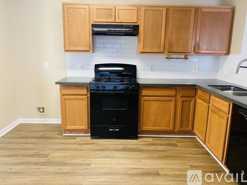 A kitchen with wooden cabinets and a black stove top oven.
