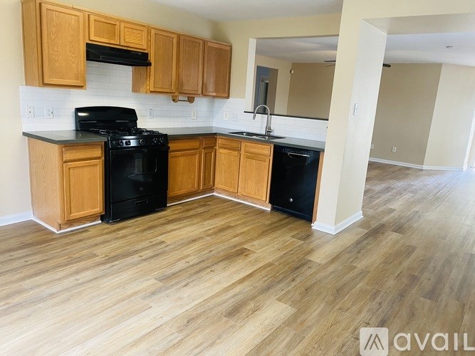 A kitchen with wooden cabinets and black appliances.