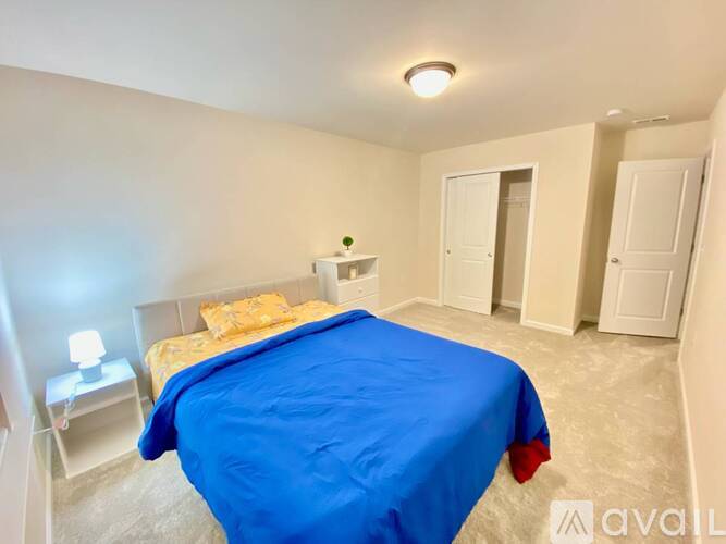 A white cabinet with a drawer is in the corner of a room.