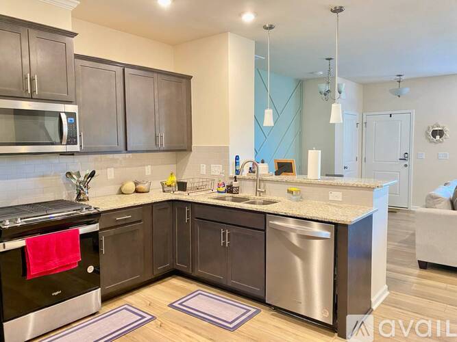 A kitchen with dark brown cabinets and a stainless steel dishwasher.