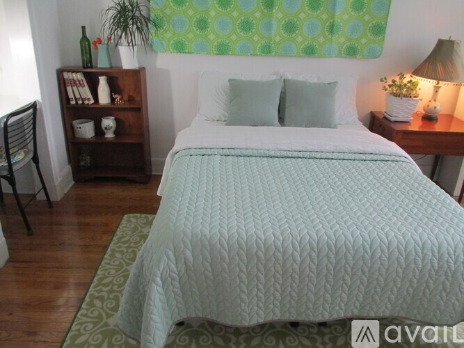 A bed with a blue comforter is in the center of the image.
