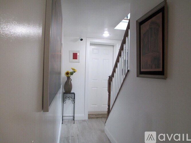 A hallway with a vase of flowers on a small table.