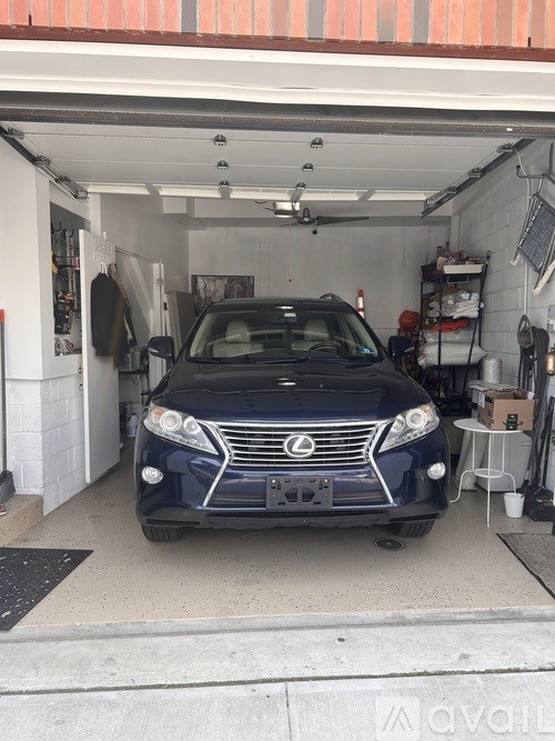 A blue Lexus is parked in a garage.